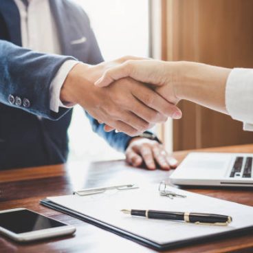 Real estate agent and customers shaking hands together celebrating finished contract after about home insurance and investment loan, handshake and successful deal.